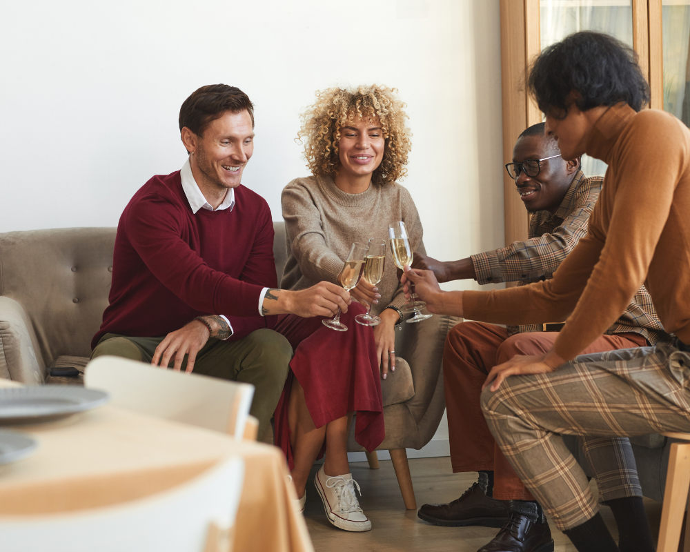 Groupe d’amis souriants trinquant dans un salon chaleureux et propre avant un repas festif