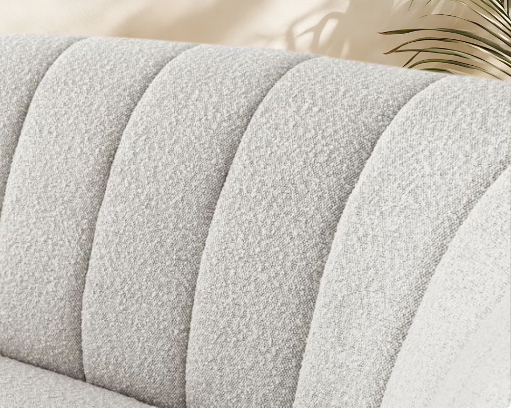 Zoom sur la texture d’un canapé en bouclette crème montrant les fibres épaisses qui retiennent poussières et odeurs – Maison Max Clean, Les astuces de Max