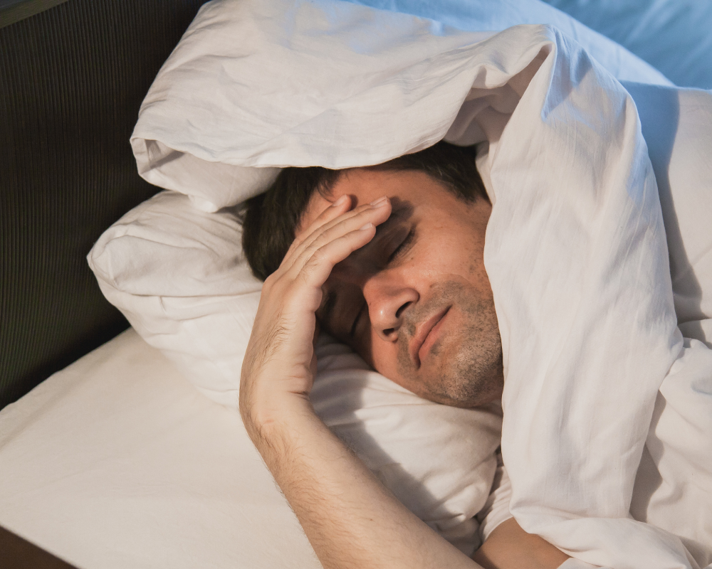 Homme fatigué dans son lit révélant un mauvais sommeil lié à l’hygiène du matelas – Maison Max Clean Les Astuces de Max Aix Marseille PACA