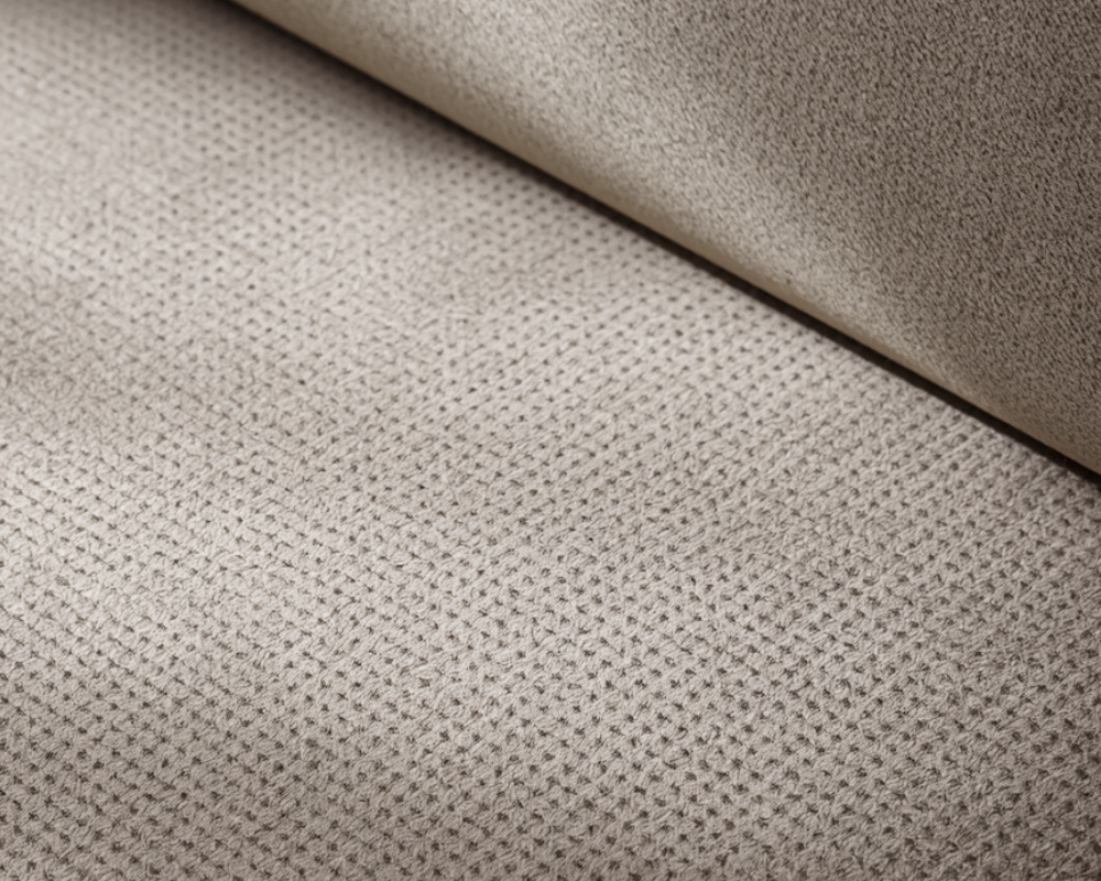 Macro texture d’un canapé en alcantara beige clair, surface technique fine et uniforme sous lumière naturelle, Les astuces de Max Maison Max Clean, nettoyage textile haut de gamme à Aix-en-Provence, Marseille et région PACA