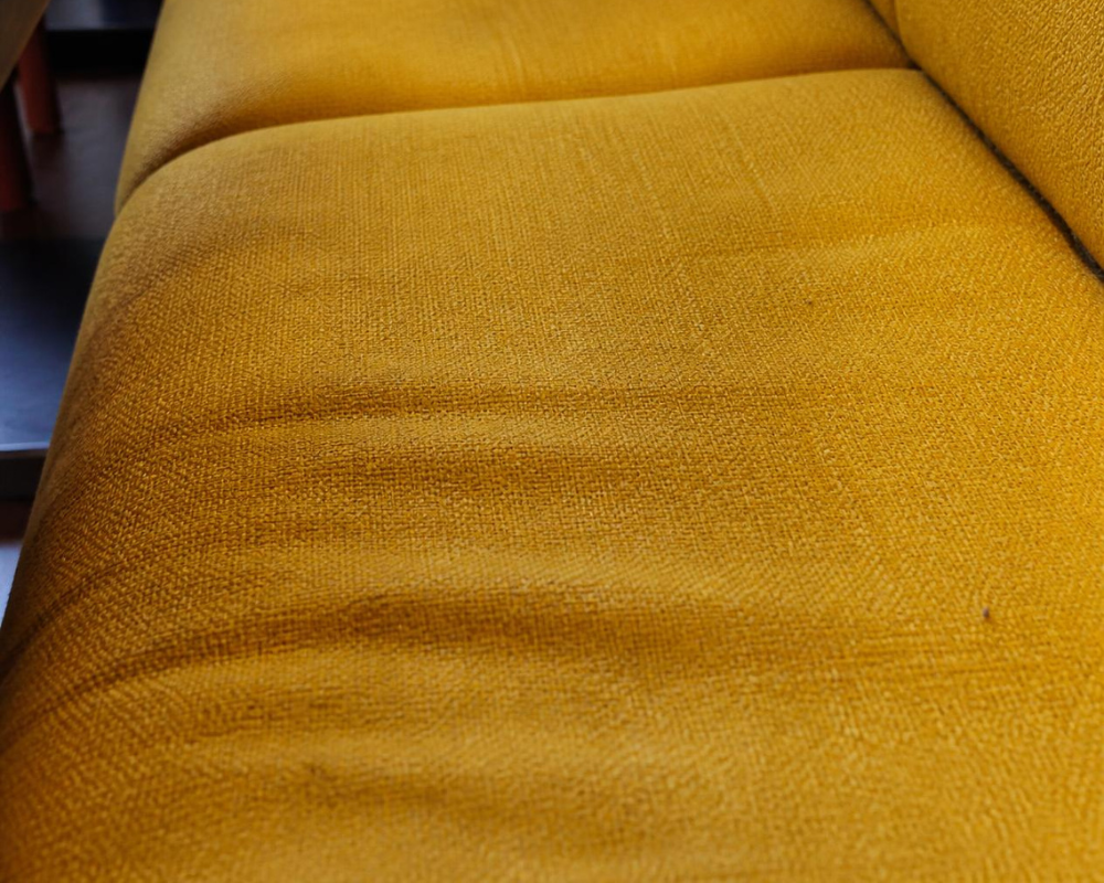 Gros plan sur les fibres d’une banquette de restaurant en tissu et ses traces d’utilisation – Les astuces de Max, Maison Max Clean