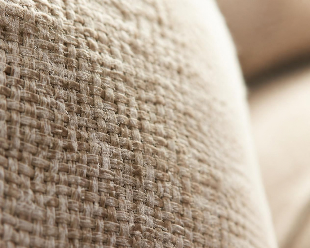 Gros plan sur les fibres d’un accoudoir de canapé en tissu, où poussière et résidus peuvent s’accumuler – Les Astuces de Max, Maison Max Clean