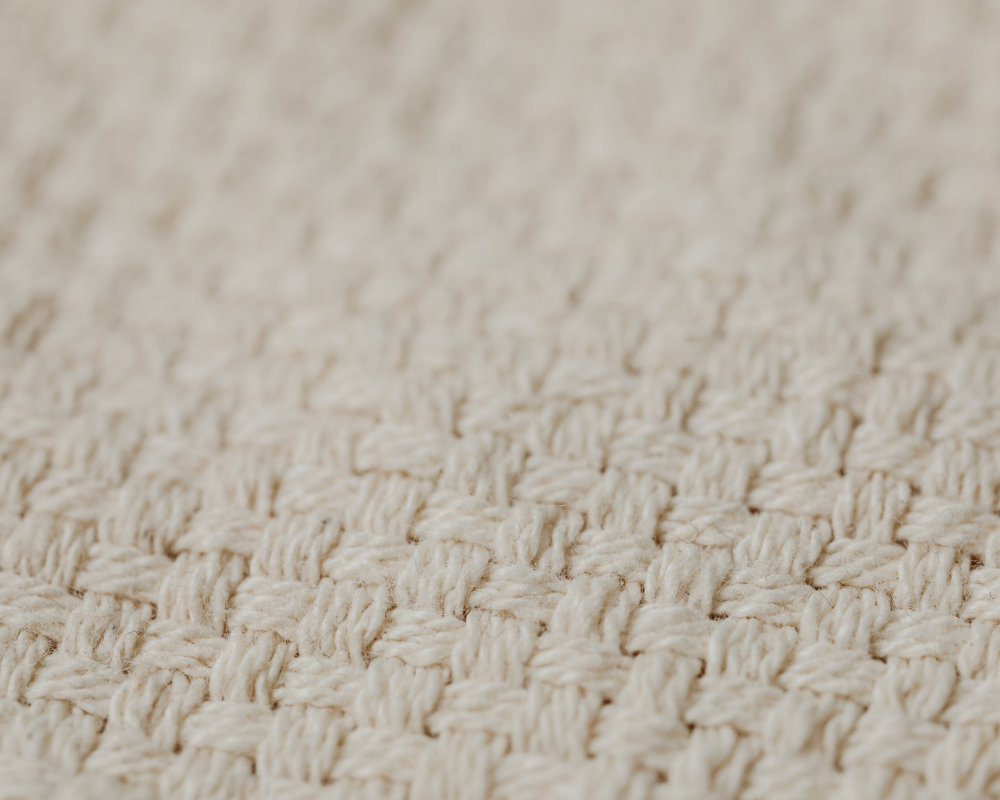 Salon chaleureux avec canapé et tapis dans une maison provençale aux fenêtres fermées en automne, illustrant les conseils des Astuces de Max de Maison Max Clean pour l’entretien des textiles à Marseille et en Provence.